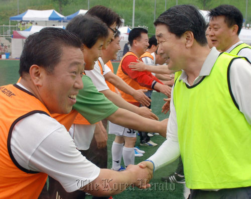 LG Electronics vice chairman Koo Bon-joon (right) shakes hands with a labor union leader during a soccer match between labor and management in Changwon, South Gyeongsang Province.     LG Electronics