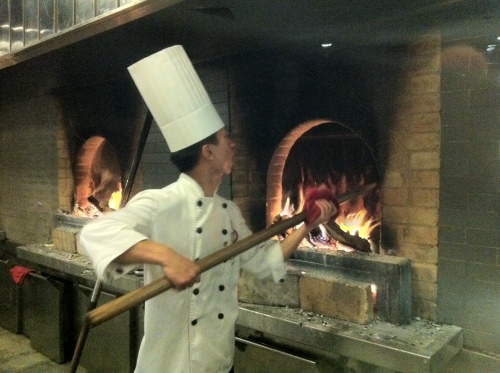 A chef at Dadong Roast Duck Restaurant in Beijing, China, cooks a whole duck in a brick oven.(Claire Lee/The Korea Herald)