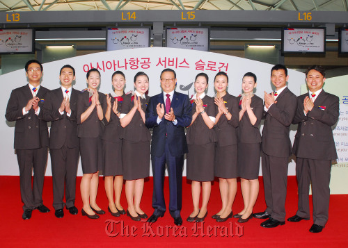 Asiana Airlines chief executive Yoon Young-doo (center) and staff members clap during a ceremony at Incheon International Airport on Thursday to introduce the carrier’s new service slogan and uniforms. Asiana Airlines
