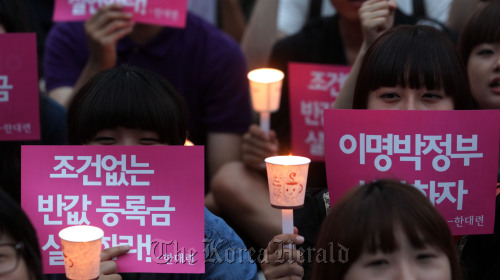 College students hold a candlelit vigil in Gwanghwamun, central Seoul, on Tuesday, demanding tuition be halved. Yonhap News