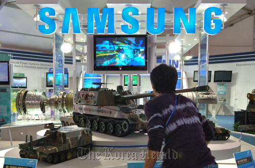 A visitor looks at a military hardware display by Samsung Techwin Co. Ltd.      Bloomberg