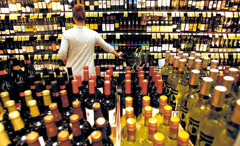 Customer Jennifer Murphy tries to decide on a bottle of wine
inside the Ralph’s grocery store in downtown Los Angeles,
California. (Los Angeles Times/MCT)