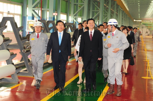 POSCO chief executive Chung Joon-yang (second from left) and Vice Governor of Jiangsu Province Zhang Wei Guo (second from right) walk through Zhangjiagang Pohang Stainless Steel’s plant in Zhangjiagang, Jiangsu Province on Monday.  POSCO