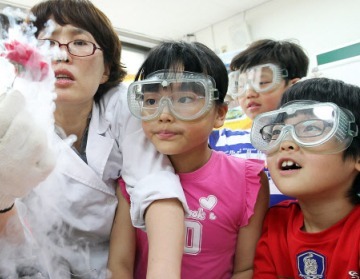 A teacher and students conduct a science experiment at a Seoul elementary school. (Yonhap News)