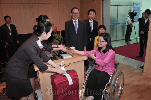 Asiana Airlines chief executive Yoon Young-doo (fourth from right) watches as disabled passengers check-in for their flights at the Hansarang Lounge that opened at Incheon International Airport on Wednesday.  Chung Hee-cho/The Korea Herald