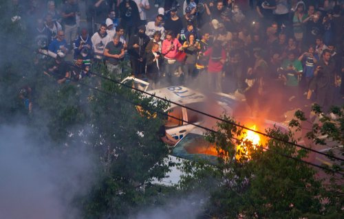 Rioters burn police cars after the Vancouver Canucks were defeated by the Boston Bruins in the NHL's Stanley Cup Final in Vancouver. (AP-Yonhap News)