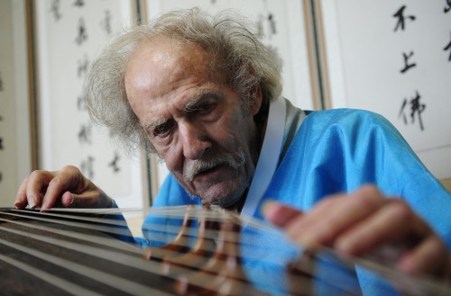 Alan C. Heyman plays 12-string gayageum at his apartment in Hwagok-dong, western Seoul, on Tuesday. (Park Hae-mook/The Korea Herald)