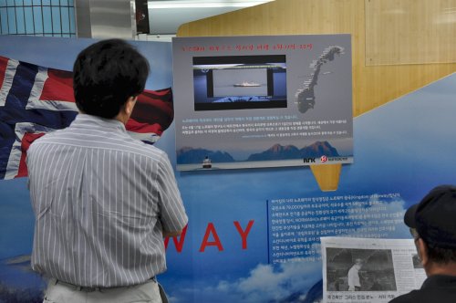 Commuters enjoy the scenic landscape of Norway during a live broadcast at Samgakji Station. (Yoav Cerralbo/The Korea Herald)