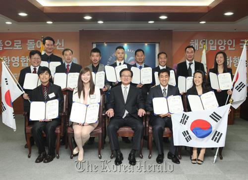 Justice Minister Lee Kwi-nam (front row, center) poses with Korean adoptees who were able to regained Korean citizenship under a new law enacted this year. Yonhap News