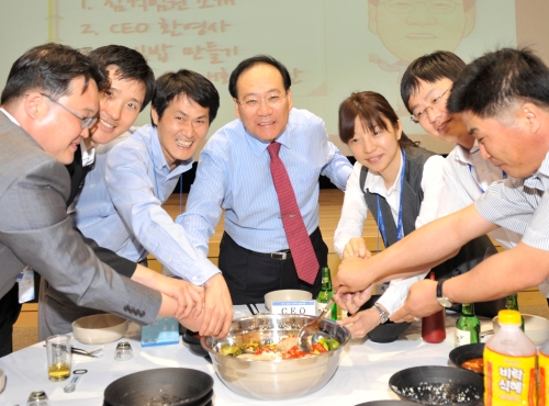 정동화 포스코건설 사장이 최근 입사한 경력직원과 화합과 결속을 다지는 의미로 비빔밥을 먹으며 소통하는 ‘비빔밥 소통’의 시간을 보냈다. 정 사장(가운데)이 지난 20일 경력직원 100여명과 함께 인천 송도 사옥 4층 대강당에 모여 대형 양푼에 나물과 밥, 고추장 등을 넣고 즉석에서 맛있는 비빔밥을 만들고 있다.