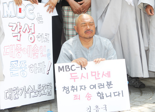 <YONHAP PHOTO-1775> '두시만세'하차관련 삭발식 한 김흥국 (서울=연합뉴스) 홍기원 기자 = MBC 라디오 표준 FM < 2시 만세 >에서 하차한 후 1인 시위를 이어가던 가수 김흥국이 17일 오후 서울 영등포구 여의도동 MBC 사옥 앞에서 삭발식을 한 후 심경을 말하고 있다. 2011.6.17 xanadu@yna.co.kr/2011-06-17 13:21:32/ <저작권자 ⓒ 1980-2011 ㈜연합뉴스. 무단 전재 재배포 금지.>
Singer Kim Heung-guk has his head shaved in front of the MBC head office in Seoul on Friday, protesting the broadcaster’s decision to dismiss him from a radio program. Yonhap News