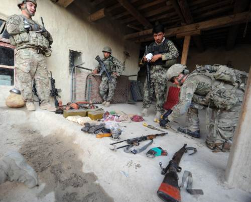 <YONHAP PHOTO-0374> US soldiers of the Viper Company (Bravo), 1-26 Infantry (L, R) examine confiscated ammunitions and guns inside a house during a raid at a village in Combat Outpost (COP) Sabari in Khost province in the east of Afghanistan on June 19, 2011, while Afghan soldiers (C) look on. The raid was done after mortar rounds were fired on the outpost a night before. Sabari district is one of the most volatile in Khost province which borders on Pakistan and is seeing a rise in coalition offensive against highly active insurgents. AFP PHOTO/TED ALJIBE /2011-06-20 07:33:35/ <저작권자 ⓒ 1980-2011 ㈜연합뉴스. 무단 전재 재배포 금지.>
U.S. soldiers examine confiscated ammunition and guns inside a house during a raid in Afghanistan on Sunday. AFP-Yonhap News