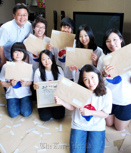 Professor Seo Kyung-deok (left) of Sungshin Women’s University and his students pose with 2,018 letters they collected from across Asia in support of PyeongChang’s bid for the 2018 Winter Olympics.  PyeongChang 2018 Bid Committee