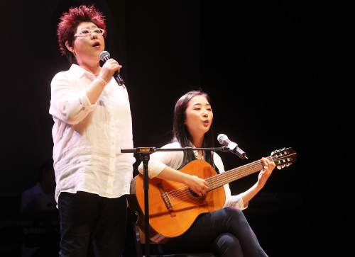 <YONHAP PHOTO-1351> 양희은, 젊은 날의 양희은과 함께 (서울=연합뉴스) 홍기원 기자 = 가수 양희은이 23일 오후 서울 서대문구 신촌동 연세대학교 100주년기념관에서 열린 데뷔 40주년 기념 뮤지컬 '어디만큼 왔니' 제작발표회에서 젊은 양희경 역을 맡은 배우 이하나와 극중 한 장면을 노래하고 있다. 2011.6.23 xanadu@yna.co.kr/2011-06-23 16:01:42/ <저작권자 ⓒ 1980-2011 ㈜연합뉴스. 무단 전재 재배포 금지.>
Yang Hee-eun sings “Morning Dew” with Lee Ha-na, an actress who will be 20-year-old Yang in the musical “How far have you come?” at a press rehearsal last week. Yonhap News