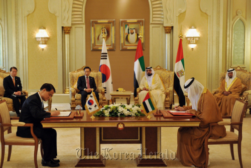 President Lee Myung-bak (third from left) and UAE president Sheikh Khalifa bin Zayed al-Nahayan (third from right) watch as KEPCO president Kim Ssang-su (front left) and chairman of Emirates Nuclear Energy Co. Khaldoon Khalifa al-Mubarak (front right) sign a contract to build a $40 billion nuclear reactors for UAE in December 2009 in Abu Dhabi.  Cheong Wa Dae