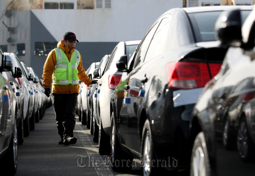 A worker inspects vehicles bound for export at the port in Pyeongtaek, Gyeonggi Province.  Bloomberg