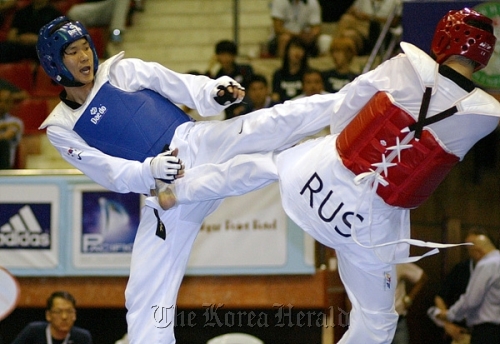 Korea’s Cha Dong-min delivers a kick to Gadzhi Umarov of Russia in the men’s over-80 kg final of the WTF qualification tournament in Baku, Azerbaijan, Sunday.  WTF
