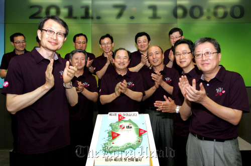 LG Uplus vice chairman and CEO Lee Sang-chul (center) with colleagues to celebrate the launch of LTE services. Yonhap News