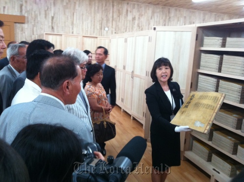 Researcher Song Soon-ok at the Academy of Korean Studies shows a copy of the Royal Genealogy of Joseon Dynasty to the members of Korea’s jongga, the prestigious households descended from distinguished ancestors through the eldest son of each generation, at the newly opened Jangseogak Archives of the Academy of Korean Studies in Seongnam, Gyeonggi Province, Tuesday.  Claire Lee/The Korea Herald