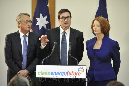 Australian Minister of Climate Change and Energy Efficiency Greg Combet (center) speaks as Treasurer Wayne Swan (left) and Prime Minister Julia Gillard listen during a news conference at Parliament House in Canberra on Sunday.  Bloomberg