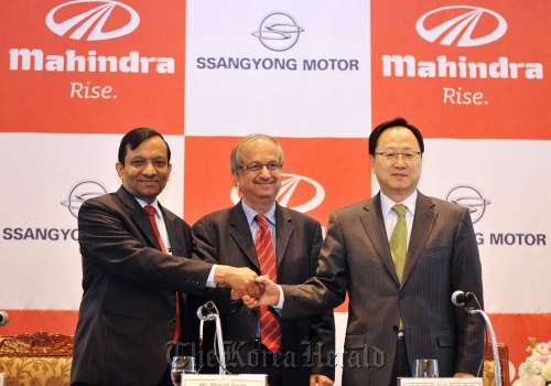 Ssangyong Motor CEO Lee Yoo-il (right) poses with Mahindra and Mahindra CFO Bharat Doshi (center) and the Indian firm’s president for automotive and farm sector Pawan Goenka at a press conference in Seoul last March.   Ssangyong Motor Co.