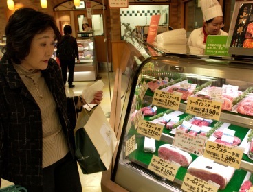 This file photo shows a Japanese woman browsing for beef in a food hall in Tokyo. (Bloomberg)
