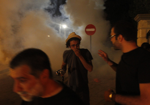 <YONHAP PHOTO-0214> Protesters run from tear gas after riot police deployed it during a protest over a fatal blast at a naval base that killed 12, outside of Presidential palace in Nicosia, Cyprus, Tuesday, July 12, 2011. Protesters were stopped by riot police at an inner gate about 100 meters from the palace. Minor scuffles broke out between a few stone-throwing youths and police who fired tear gas, but no arrests or injuries were reported. It was unclear whether President Dimitris Christofias was in the building. (AP Photo/Petros Karadjias)/2011-07-13 06:02:27/ <저작권자 ⓒ 1980-2011 ㈜연합뉴스. 무단 전재 재배포 금지.>
Cypriot protesters run outside of the presidential palace in Nicosia on Tuesday. AP-Yonhap News