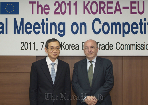 Fair Trade Commission chief Kim Dong-soo (left) poses with Joaquin Almunia, vice president of the European Commission, after holding a policy meeting in Seoul on Friday.   Yonhap News
