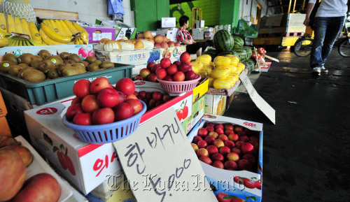계속되는 장마와 집중호우로 농수산물 가격이 꿈틀거리고 있다. 12일 서울 가락동 농수산물 시장에서 한 상인이 계절과일을 정리하고 있다.<br />김명섭 기자 msiron@
A merchant takes care of her shop at the Garak-dong market for agricultural and marine products in Seoul on Sunday.
Kim Myung-sub/The Korea Herald