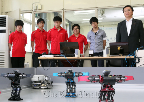 Knowledge Economy Minister Choi Joong-kyung (far right) watches robots along with students at Seoul Robot High School in southern Seoul on Tuesday. Yonhap News