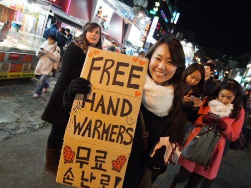 A Seoul Giving Club member passes out free hand warmers at a previous event.   Seoul Giving Club