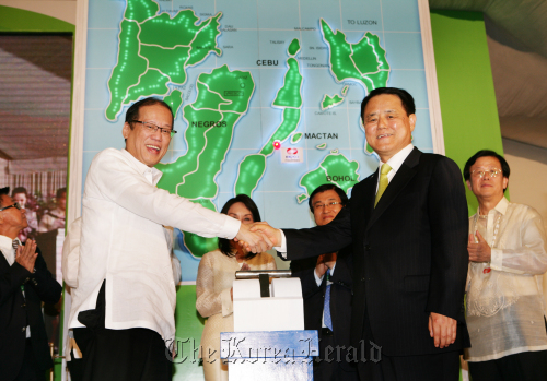 President Benigno Aquino (left) of the Philippines shakes hands with Korea Electric Power Corp. CEO Kim Ssang-su at the ceremony marking the completion of a power plant in Cebu on June 27.     Yonhap News
