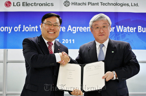 LG Electronics’ home appliance president Lee Young-ha (left) shakes hands with Hitachi Plant Technologies president  Toshiaki  Higashihara after signing an agreement to establish a new joint venture named LG-Hitachi Water Solutions Co. at LG Twin Towers in Yeouido, Seoul, early this month.   LGE