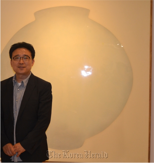 Kang Ik-joong poses in front of his work “Moon Jar.” Kang Ik-joong