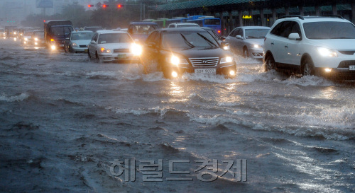 27일 서울에 집중호우가 내려 도심 곳곳이 침수가 된 가운데 여의도 주변도로가 침수 돼 출근길 차량들이 아슬아슬하게 지나가고 있다./ 안훈기자 rosedale@ 2011.07.27
27일 서울에 집중호우가 내려 도심 곳곳이 침수가 된 가운데 여의도 주변도로가 침수 돼 출근길 차량들이 아슬아슬하게 지나가고 있다./ 안훈기자 rosedale@ 2011.07.27
27일 오전 서울에 시간당 최대 100㎜ 이상의 폭우가 쏟아져 도심 곳곳이 침수되고 교통이 마비됐다. 여의도 주변도로에서 출근길 차량들이 물살을 가르며 아슬아슬하게 지나가고 있다. 안훈 기자/rosedale@heraldm.com