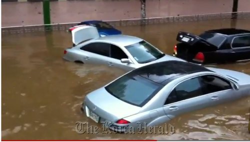 Imported cars are stranded on a submerged street due to heavy rain in Seocho-dong, southern Seoul, Wednesday.   YuTube capture