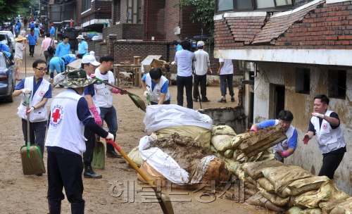 29일 오전 집중호우로 피해를 입은 서울 서초구 방배2동 전원마을에서 대한적십자사 등 자원봉사단체들이 복구활동을 하고 있다.<br />김명섭 기자 msiron@
장대비가 소강상태에 접어든 29일 오전, 지난 3일간의 집중호우로 침수 및 산사태 피해를 본 서울 서초구 방배2동 전원마을에서 대한적십자사 등 자원봉사단체 회원들이 쓸려내려온 잔해를 치우는 등 복구 활동을 벌이고 있다. 김명섭 기자/msiron@