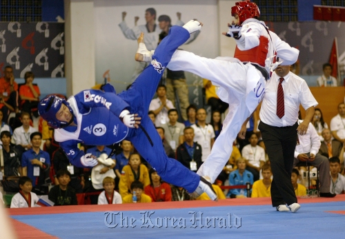 A Korean athlete (left) competes against an athlete from Russia in the five-member kyorugi team final match at the World Poomsae Championships in Vladivostok, Russia, Saturday.  WTF