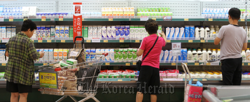 Customers purchase milk at a discount store in Seoul on Tuesday. Yonhap News