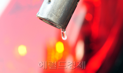 24일 오전 두바이유가 30개월만에 100달러를 돌파한 가운데 서울 용산의 한 주유소에 한국경제에 빨간등이 켜진 듯 주유를 하는 브레이크등뒤로 휘발유가 한 방울 떨어지고 있다. 박해묵 기자/mook@heraldm.com