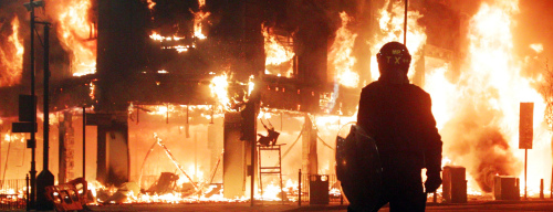 Fire rages through a building in Tottenham, north London early Sunday, as trouble flared after members of the community took to the streets to protest over the alleged police shooting death of a local man last Thursday. The riots started with a street protest Saturday and ended Sunday morning with buildings and vehicles set afire, including police cars, a double-decker London bus, and shops looted as police clashed with protesters. (AP-Yonhap News)