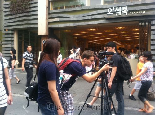 Harvard University student Nic Galat adjusts his camera while filming in the streets of Seoul. Harvard Korea Institute