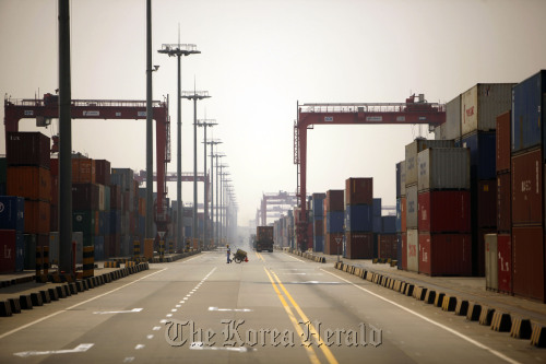 A dock worker pulls a cart through the Yangshan Deep Water Port in Shanghai.  Bloomberg