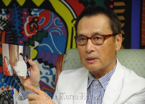 도신우 모델센터회장.<br />이상섭 기자 babtong@heraldm.com 2011.08.11\r\nTo Shin-woo shows a photo of Andre Kim and himself taken in 2006 in Cambodia when Kim held the first-ever fashion show at Angkor Wat.  Lee Sang-sub/The Korea Herald