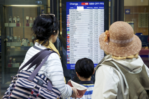 <YONHAP PHOTO-0244> Tourists read a currency exchange rate chart at the central train station in Zurich, Switzerland, on Thursday, Aug. 11, 2011. The franc weakened after Swiss central bank Vice President Thomas Jordan said a temporary peg of the franc is part of the bank's toolbox, as policy makers struggle to stem a record-breaking rally. Photographer: Gianluca Colla/Bloomberg/2011-08-12 06:49:23/ <저작권자 ⓒ 1980-2011 ㈜연합뉴스. 무단 전재 재배포 금지.>\r\nTourists read a currency exchange rate chart at the central train station in Zurich on Thursday.  Bloomberg