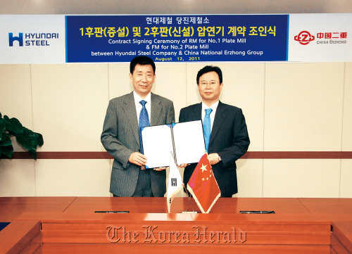 Hyundai Steel’s chief procurement officer Kim Beom-su (left) and China Erzhong’s general manager Sun Derun pose after signing a contract for rolling mill supply at the Korean company’s Seoul office in Yangjae-dong on Friday.  Hyundai Steel