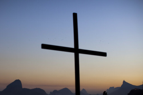 Framed by a backdrop that includes Sugarloaf Mountain, left, and the monument Christ the Redeemer, right, a cross honoring slain Judge Patricia Acioli is silhouetted against a dusk sky in Niteroi, a city just across Guanabara Bay from Rio de Janeiro, Brazil, Friday. (AP-Yonhap News)