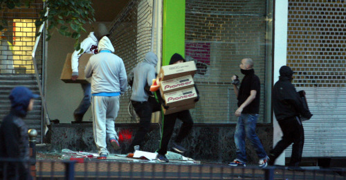 <YONHAP PHOTO-1483> In this Tuesday Aug. 9, 2011 photo, youths run from an electronics store in Birmingham, England as disturbances saw looting and vehicles set alight. As Britain comes to grips with the causes of the past week's descent into anarchy, Prime Minister David Cameron has identified the growth of gangs as a key factor and is recruiting high-profile American anti-gang experts to help bring them to heel. (AP Photo/David Jones/PA Wire) UNITED KINGDOM OUT NO SALES NO ARCHIVE/2011-08-14 19:33:35/ <저작권자 ⓒ 1980-2011 ㈜연합뉴스. 무단 전재 재배포 금지.>\r\nLooters run from a store in Birmingham last Tuesday during riots that left five dead, and thousands arrested. AP-Yonhap News