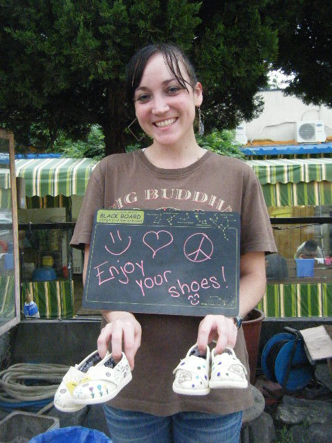 Sharing page pics Aug 18\r\nA volunteer shows shoes she decorated at the Daegu “Style Your Sole” event.