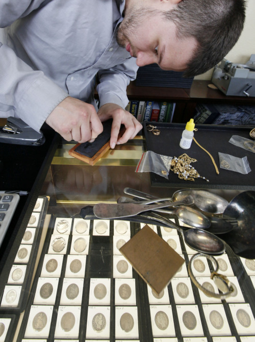 <YONHAP PHOTO-0122> In this July 27, 2011 photo, Davis Hardgrove performs a "scratch test" on a piece of gold jewelry that a customer brought in to sell at a coin shop, in Seattle. In December 2007, gold sold for about $840 an ounce. A little over a year later, it rose above $1,000 for the first time. It climbed gradually for the next two years. Then in March 2011, it began rocketing up. On Tuesday, Aug. 16, 2011, it traded at $1,788 an ounce, up 26 percent this year. (AP Photo/Elaine Thompson)/2011-08-18 01:06:07/ <저작권자 ⓒ 1980-2011 ㈜연합뉴스. 무단 전재 재배포 금지.>\r\nDavis Hardgrove performs a “scratch test” on a piece of gold jewelry that a customer brought in to sell at a coin shop in Seattle.  AP-Yonhap News